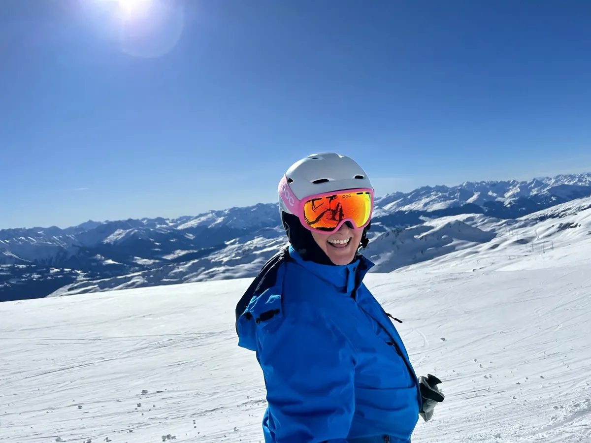 A skier in front of a snowy alpine panorama