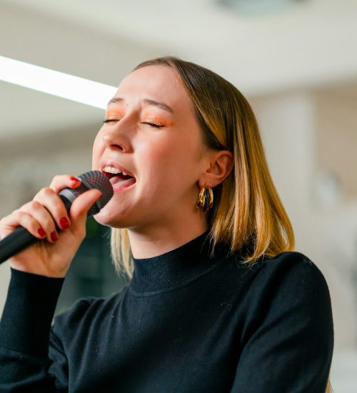 young girl sings in a vocal lesson with a microphone in her hands during a lesson at a music school